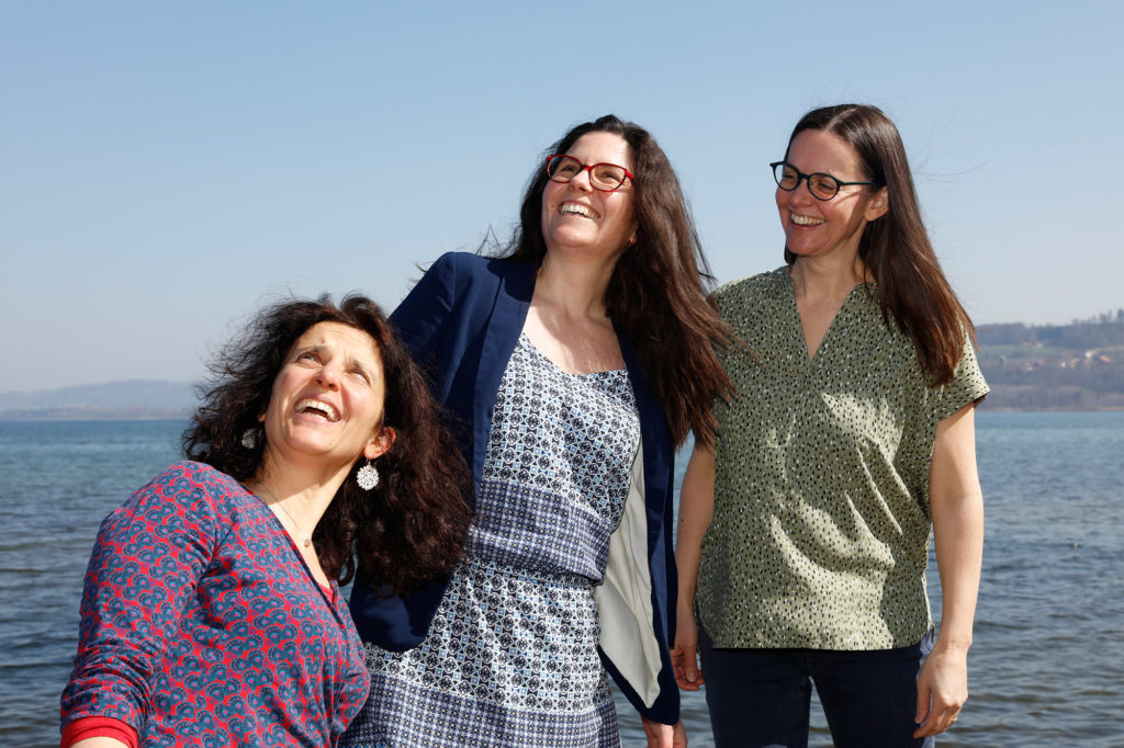 Portrait de l'équipe Kaléïdoscope. Les trois membres regardent vers le haut en souriant.